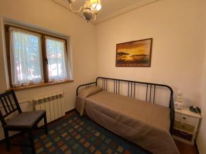 1 dormitorio con cama, silla y ventana en La Casa de Mica, en Cotillo