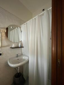 a bathroom with a white shower curtain and a sink at Hotel Classicano in Ravenna