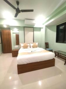 Schlafzimmer mit einem großen Bett und einem Deckenventilator in der Unterkunft Everest Stays Rooms and Dormitory in Mumbai
