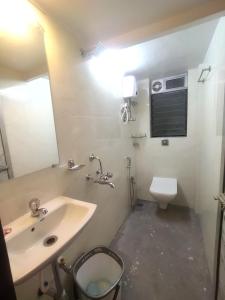 La salle de bains est pourvue d'un lavabo et de toilettes. dans l'établissement Everest Stays Rooms and Dormitory, à Mumbai