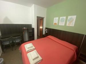 a bedroom with a red bed and a desk at Hotel Belgrano in San Luis