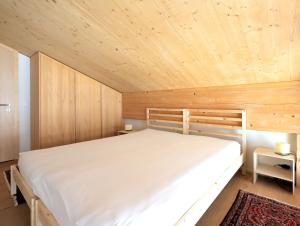 een slaapkamer met een bed en een houten plafond bij Erzhornblick in Arosa