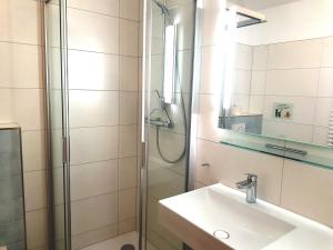 a bathroom with a sink and a shower at Ferienwohnungen im Haus Bi Henny in Baabe