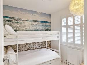 1 dormitorio con literas y un mural de playa en The Beach House - Wittering, en East Wittering