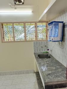 een badkamer met een wastafel en een aantal ramen bij Maria Vilas in Tirunelveli