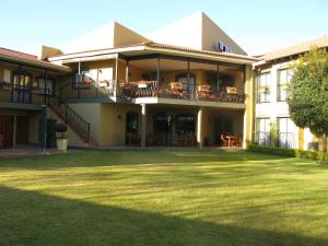 a large building with a lawn in front of it at Benvenuto Hotel & Conference Centre in Johannesburg