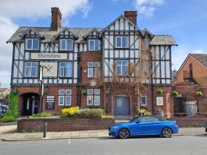 a blue car parked in front of a building at Sheridans Budget Accomodation in Wallasey