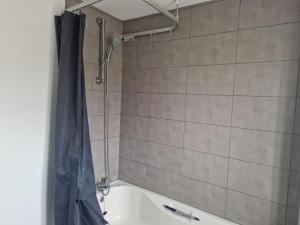 a bathroom with a shower and a bath tub at Charming 3Bed House in Strood in Wainscot