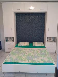 a large bed in a room with a wall at Studio avec piscine partagee jardin clos et wifi a Baie Mahault in Baie-Mahault