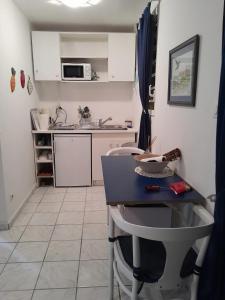 a small kitchen with a table and a sink at Studio avec piscine partagee jardin clos et wifi a Baie Mahault in Baie-Mahault