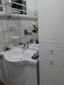 a white bathroom with a sink and a mirror at Studio avec piscine partagee jardin clos et wifi a Baie Mahault in Baie-Mahault