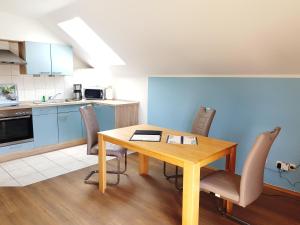 a kitchen and dining room with a wooden table and chairs at Ferienwohnungen im Haus Bi Henny in Baabe