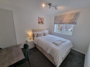 1 dormitorio con cama, mesa y ventana en Charming 3Bed House in Strood en Wainscot