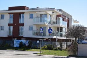 an apartment building with a handicapped sign in front of it at Apartament przy latarni z garażem Niechorze in Niechorze