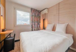 ソースハイムにあるB&B HOTEL Mulhouse Sausheimのベッドルーム(大きな白いベッド1台、窓付)