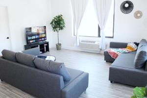 un salon avec deux canapés et une télévision dans l'établissement Cozy Stylish Apartment near Newark, NJ Airport, à Elizabeth