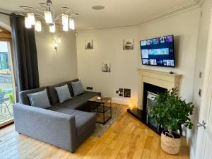 a living room with a couch and a fireplace at 3 Castle Hume Court Holiday House in Enniskillen