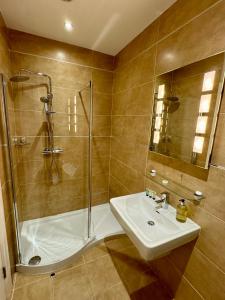 ein Bad mit einer Dusche, einem Waschbecken und einer Dusche in der Unterkunft 3 Castle Hume Court Holiday House in Enniskillen