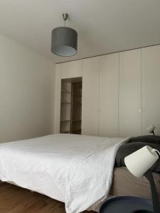 a white bedroom with a bed and a lamp at No Matter Stay - Chic and classy - Arc de Triomphe in Paris