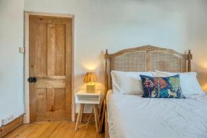 a bedroom with a bed and a table with a lamp at Stylish 2BD with Private Garden and Sauna in Oxford