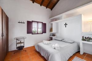 a bedroom with two beds and a cross on the wall at Alandroal Nature & Pool Retreat- Courela dos Tojos in Alandroal