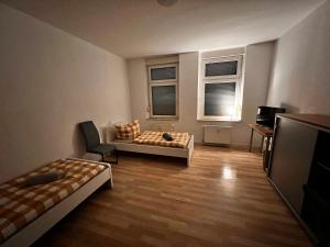 ein Wohnzimmer mit einem Bett und einem Sofa sowie zwei Fenstern in der Unterkunft Mitten im Herzen von Magdeburg in Magdeburg