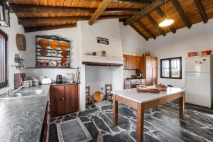 a kitchen with a table and a refrigerator at Alandroal Nature & Pool Retreat- Courela dos Tojos in Alandroal