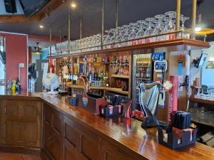 un bar avec un comptoir en bois et un bar dans l'établissement Sheridans Budget Accomodation, à Wallasey