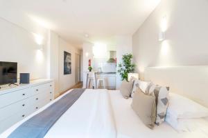 Un dormitorio blanco con una cama grande y una cocina. en Torre Alta Apartments, en Lagos