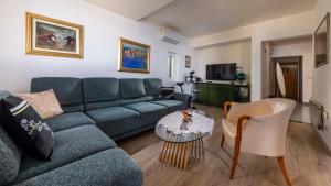 sala de estar con sofá azul y mesa en Apartment Golden Creek Magic View, en Dubrovnik
