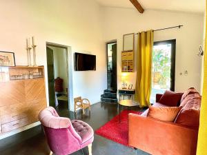 ein Wohnzimmer mit 2 Stühlen und einem TV in der Unterkunft Maison, centre ville, terrasse, parking, calme in Sète