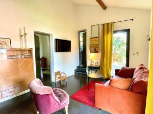 a living room with two chairs and a tv at Maison, centre ville, terrasse, parking, calme in Sète