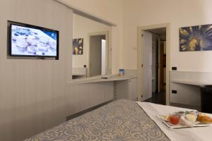 um quarto de hotel com uma cama e uma televisão na parede em Hotel City Legnano em Legnano