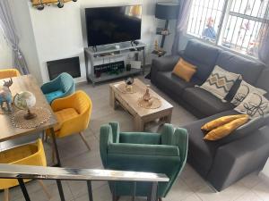 sala de estar con sofá, sillas y TV en Casa Sortino Rizzo en San Miguel de Salinas