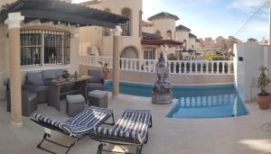 a patio with two chairs and a table and a pool at Casa Sortino Rizzo in San Miguel de Salinas
