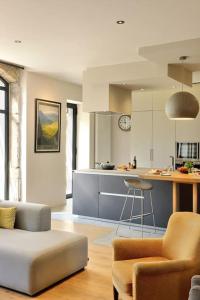 ein Wohnzimmer mit einem Sofa und einer Küche in der Unterkunft Magnifique Villa, idéal famille Ste Foy Les Lyon in Sainte-Foy-lès-Lyon