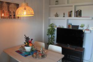 a living room with a table with a television and a table sidx sidx at Apartamentos Vado - Arco de Elvira in Granada