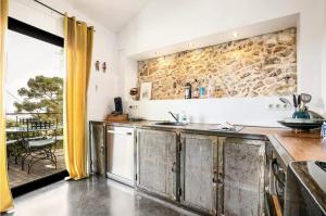 a kitchen with a stone wall and a counter at Maison, centre ville, terrasse, parking, calme in Sète