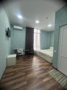 a room with a bedroom with a bed and a table at Hotel Saba in Rustavi