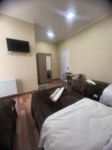 Habitación de hotel con 2 camas y mesa en Hotel Saba, en Rustavi