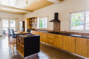 a kitchen with wooden cabinets and a black island at VILLA MAHATSINJO in Antsiakambony