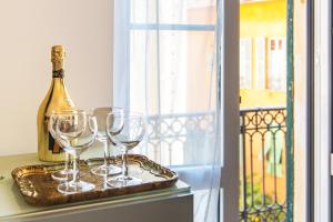 a tray with wine glasses and a bottle on a window at MARNE IV - Cosy 2 pièces en plein centre de Menton in Menton
