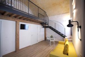a living room with a yellow couch and a staircase at Casa Nera GuestHouse in Montescaglioso