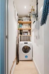 a washer and dryer in a tiny house at Guest Homes - Bakers Quay Apartment in Gloucester