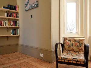 une chaise assise dans une pièce avec fenêtre dans l'établissement 5 bed property in Hastings Sussex 57217, à Hollington