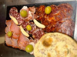 talerz jedzenia z mięsem, winogronami i pizzą w obiekcie Guest Homes - Bakers Quay Apartment w mieście Gloucester