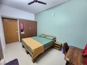 a bedroom with a bed and a ceiling fan at SQUARSTAY in Bangalore