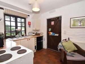 a kitchen with a stove top oven next to a door at 2 Bed in Cilgerran FB173 in Cilgerran
