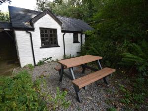 una mesa de picnic de madera frente a un edificio en 2 Bed in Cilgerran FB173 en Cilgerran