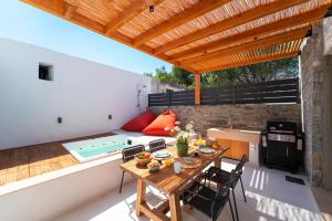 a patio with a table and a swimming pool at Atria luxury experience in Kattavía